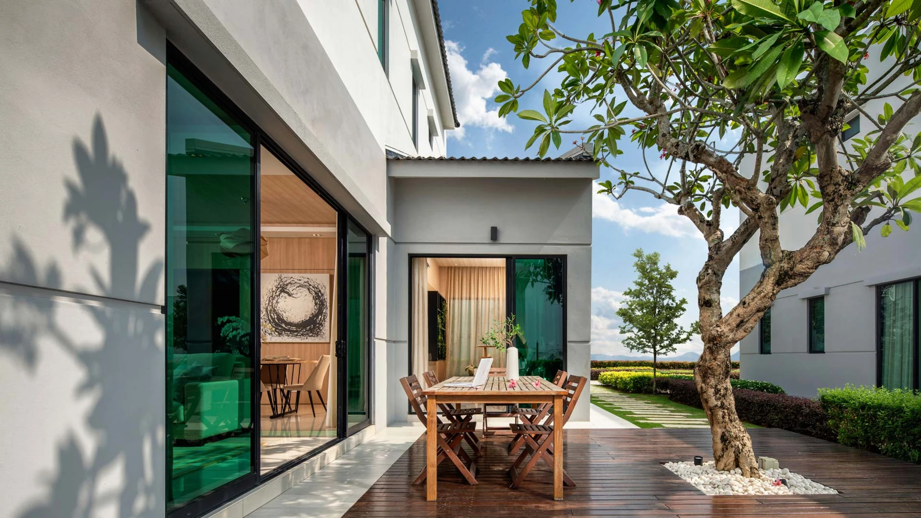 Official Eco Horizon lifestyle image showing a dining space opening onto a private garden